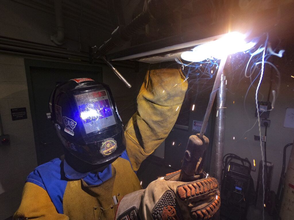 Welder in auto-darkening helmet